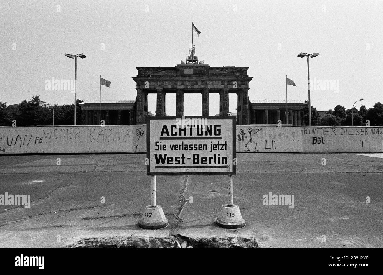 A section of the Berlin Wall at the Brandenburg Gate, seen from the western side of the divide. The Berlin Wall was a barrier constructed by the German Democratic Republic (GDR, East Germany) starting on 13 August 1961, that completely cut off West Berlin from surrounding East Germany and from East Berlin. The Wall was opened on 9. November 1989 allowing free movement of people from east to west. Stock Photo