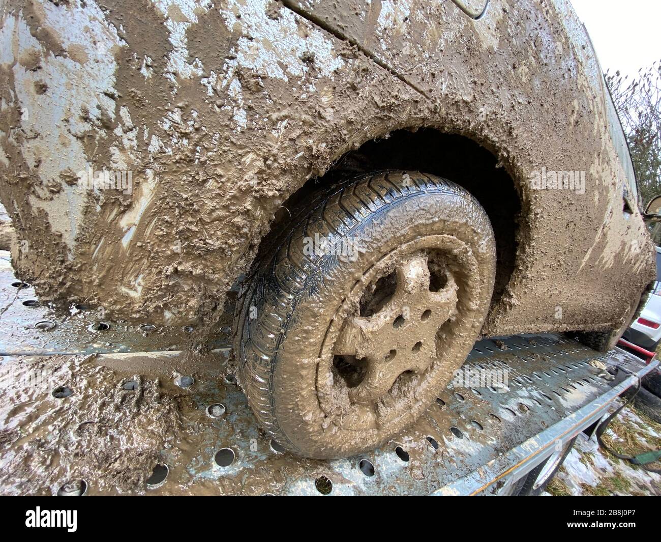 The detail of the car completely dirty by mud after the drag race on a field during winter. It needs complete cleaning of the exterior and interior. Stock Photo