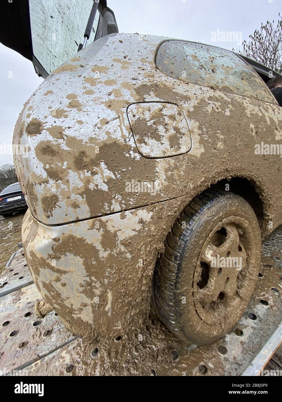 The detail of the car completely dirty by mud after the drag race on a field during winter. It needs complete cleaning of the exterior and interior. Stock Photo