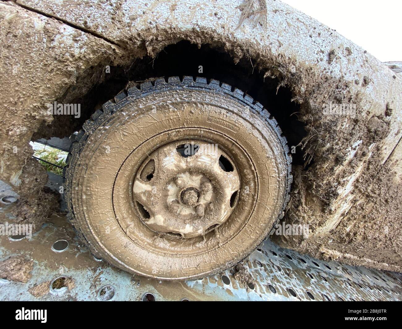 The detail of the car completely dirty by mud after the drag race on a field during winter. It needs complete cleaning of the exterior and interior. Stock Photo