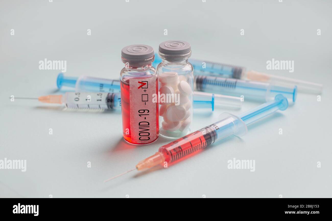 test with coronovirus c in epidemic with test tube and syringe with blood test and pills in the lab Stock Photo