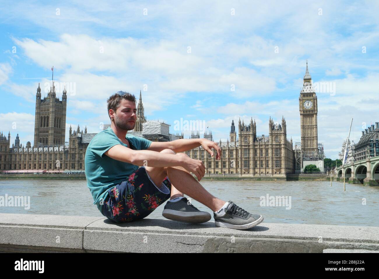 guy on city trip in London, youn men at waterfront by the river Thames
