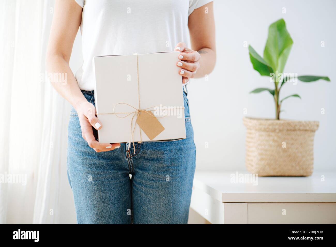 The girl is holding a white cardboard box with a label Stock Photo Alamy