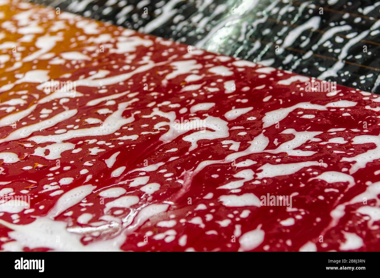 Bubbles on the red car.Car wash texture Stock Photo