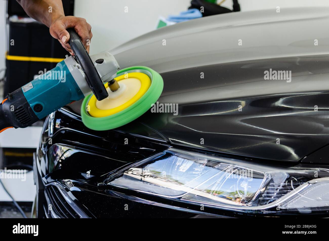 Man working for polishing, coating cars. polishing of the car will help eliminate contaminants on the surface of the car.Waxing the car surface will c Stock Photo