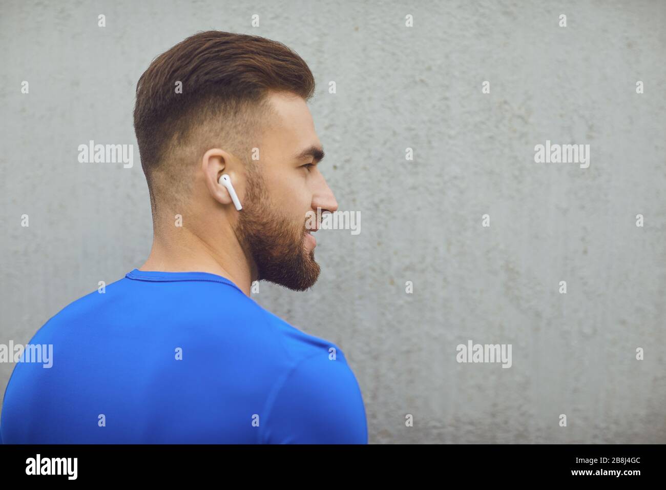 Bearded guy in sportswear on gray background. Stock Photo