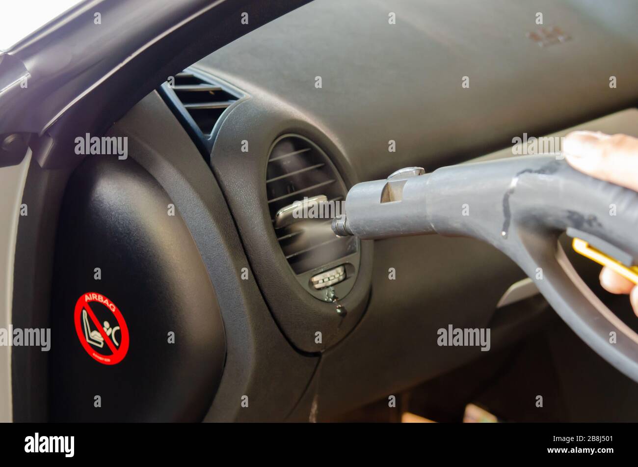 Portrait of worker use car interior steam cleaner. Vapor sterilization  Stock Photo by svitlanah