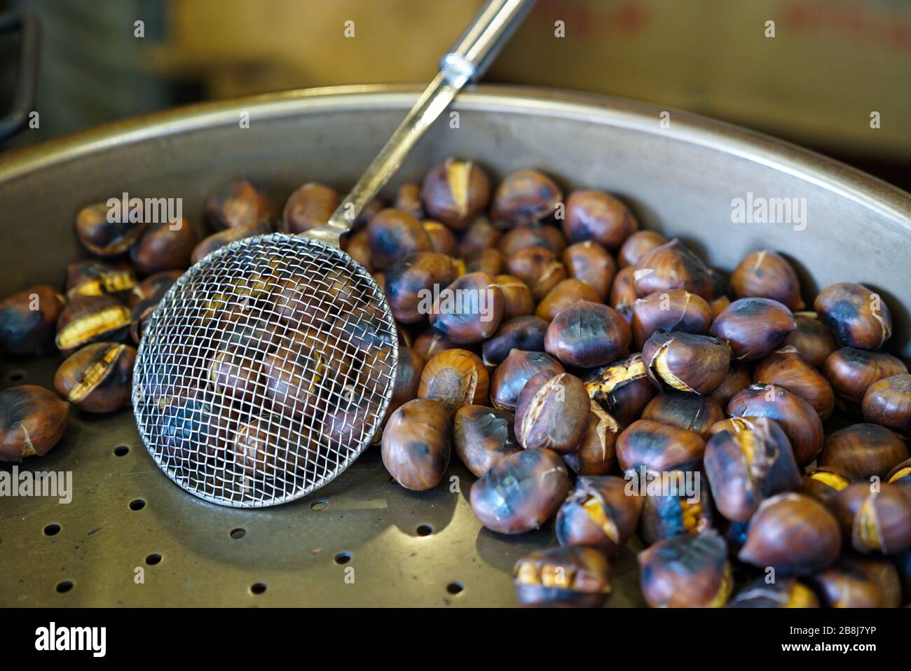 A close up view of delicious edible chestnuts being roasted on a gas
