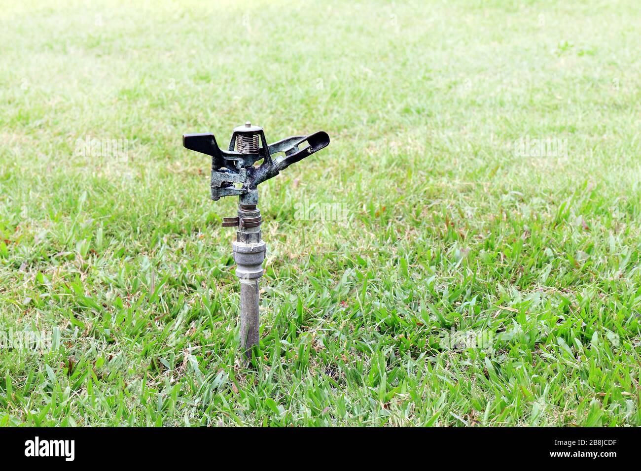 old sprinkler water automatic in garden for watering grass Stock Photo