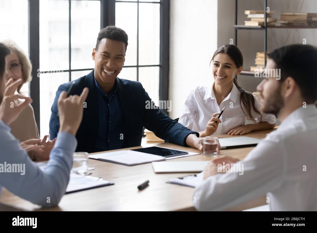Happy businesspeople joke brainstorming at office meeting Stock Photo