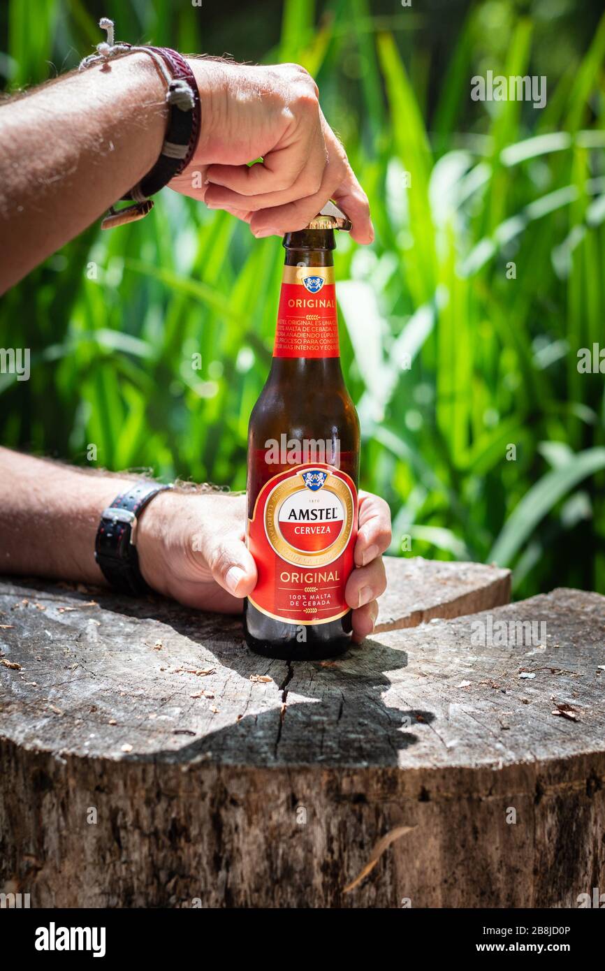 A man openning a Amstel beer bottle in the country Stock Photo
