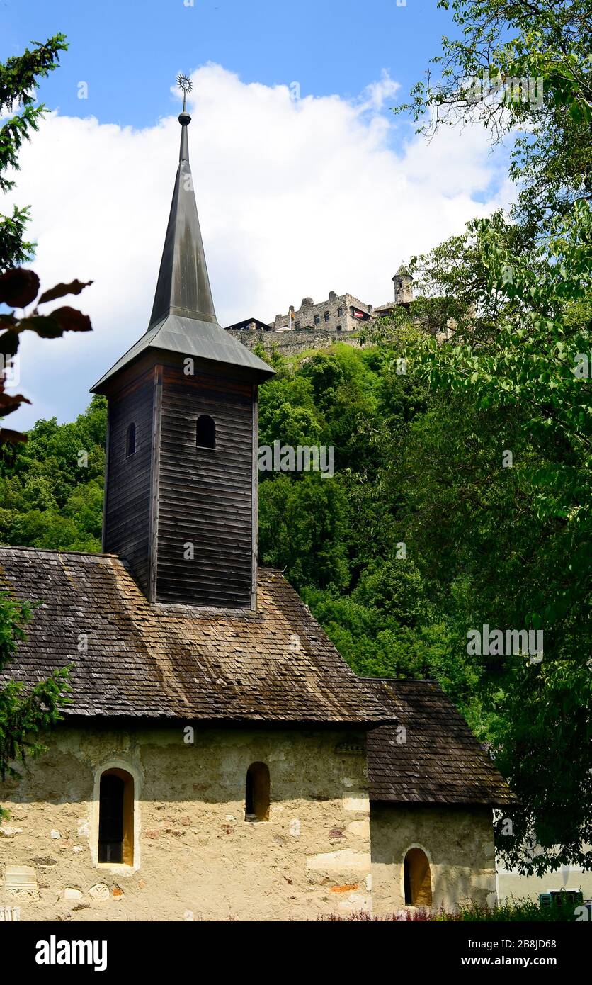 Austria, chapel in Landskron village named - church of Gratschach from 13th century - roof covered with wooden shingle and castle Landskron above Stock Photo