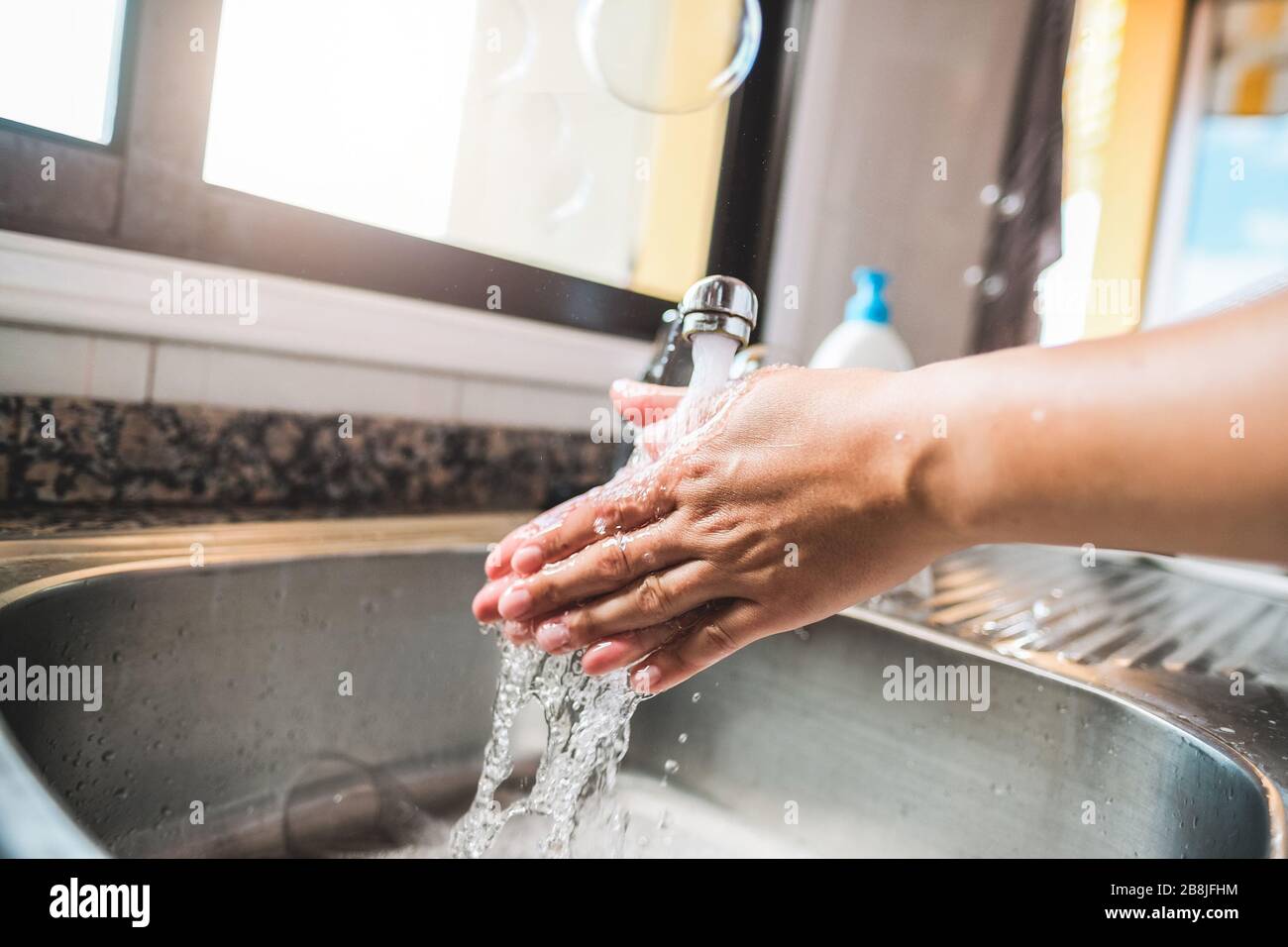 Woman washing her hands rubbing with soap for coronavirus prevention - Hygiene to stop spreading Covid 19 concept - Focus on hand Stock Photo