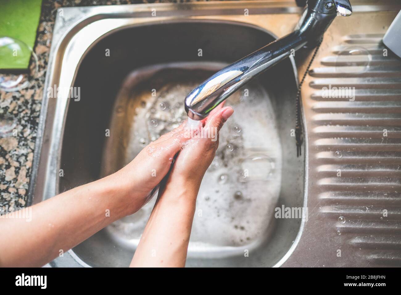 Woman washing her hands rubbing with soap for coronavirus prevention - Hygiene to stop spreading Covid 19 concept - Focus on hand Stock Photo