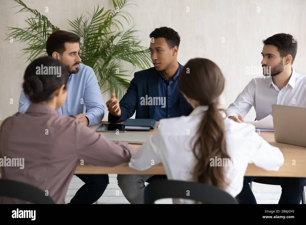 Focused diverse businesspeople brainstorm at office meeting Stock Photo