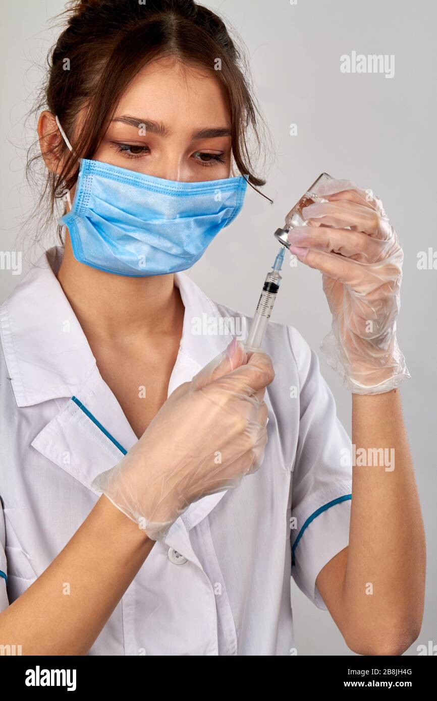 Female doctor filling syringe with medicine from the vial tube Stock Photo  - Alamy