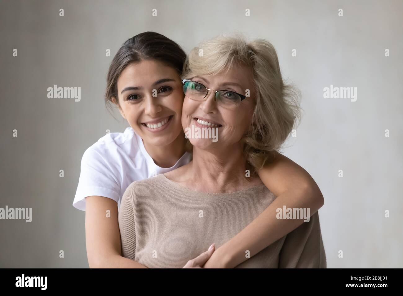 Smiling middle-aged mother and adult daughter hugging Stock Photo