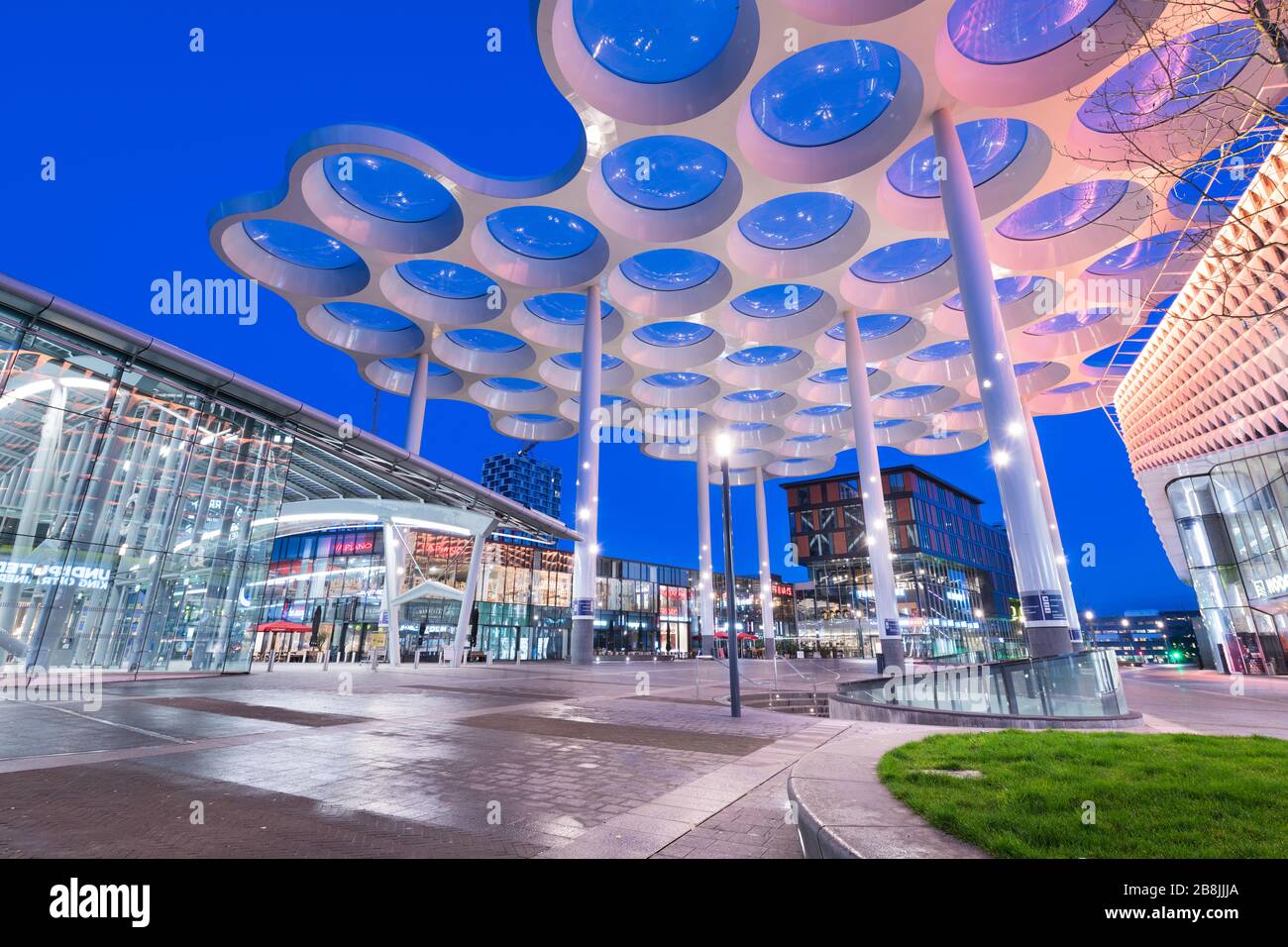 The modern architectural facade of Utrecht Centraal Station and the connected Hoog Catharijne shopping center, serving as a major transport hub.