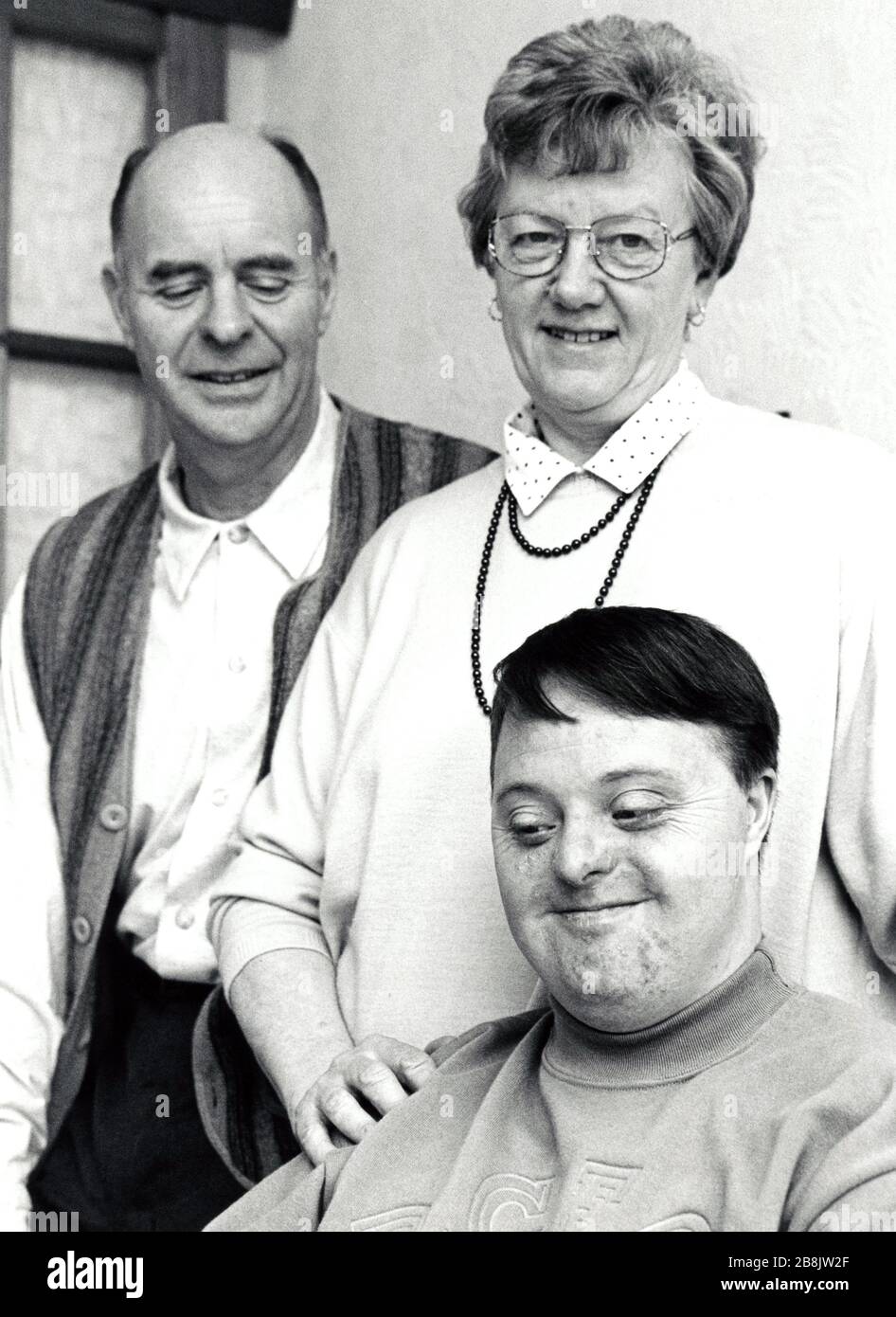 Young man with Down's Syndrome with his parents UK 1995 MR Stock Photo