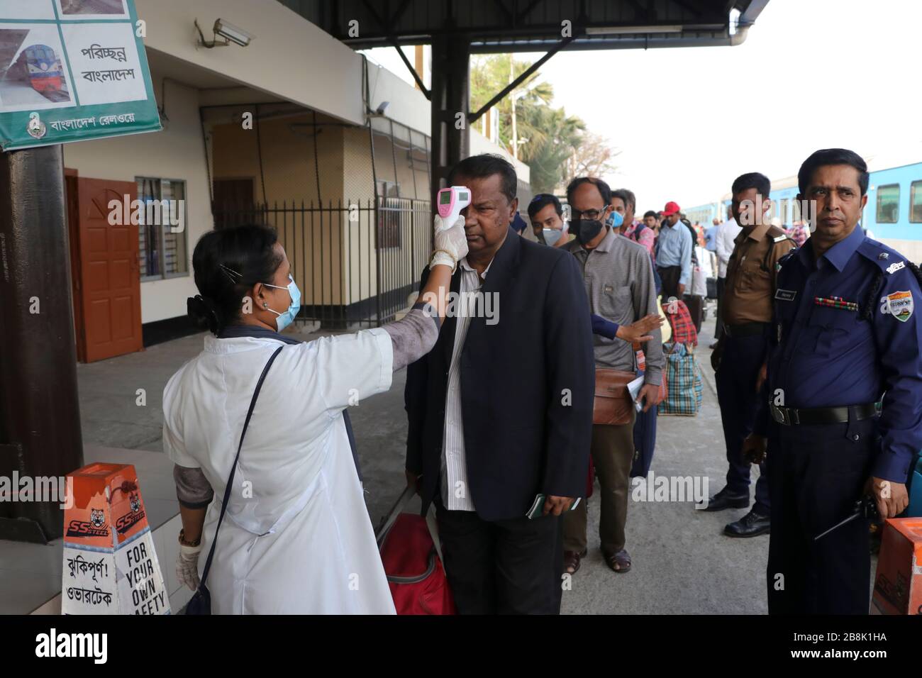 A healthcare service staffer screens the inbound passengers particularly those who arrived from India with a thermal scanner for signs Of favour at co Stock Photo