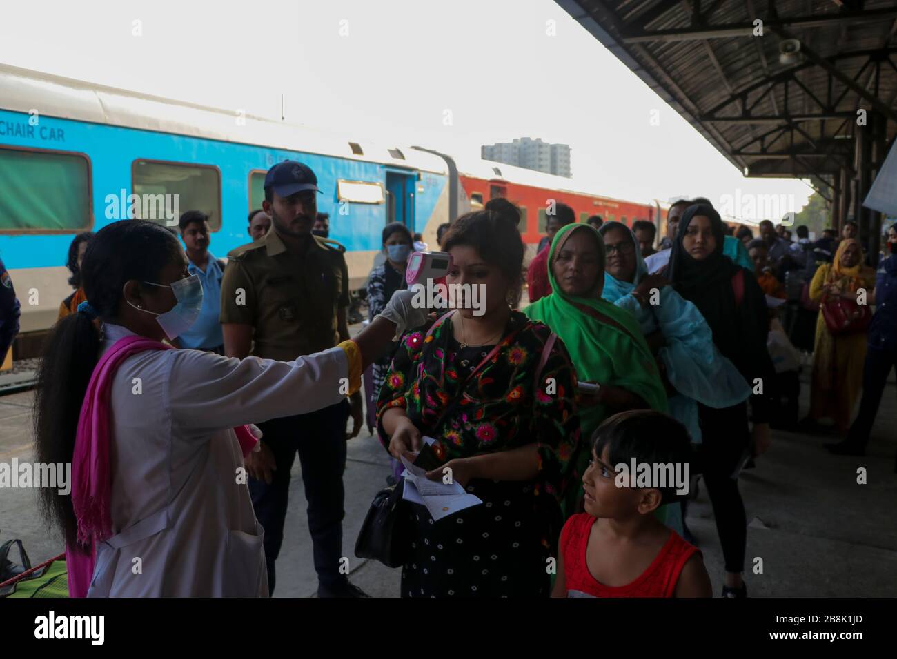 A healthcare service staffer screens the inbound passengers particularly those who arrived from India with a thermal scanner for signs Of favour at co Stock Photo