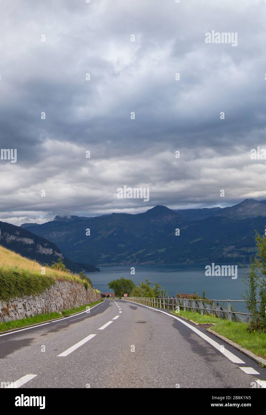 Local road and view on beautiful lake Thun and Swiss Alps. City of Sigriswil, canton Bern, Switzerland Stock Photo
