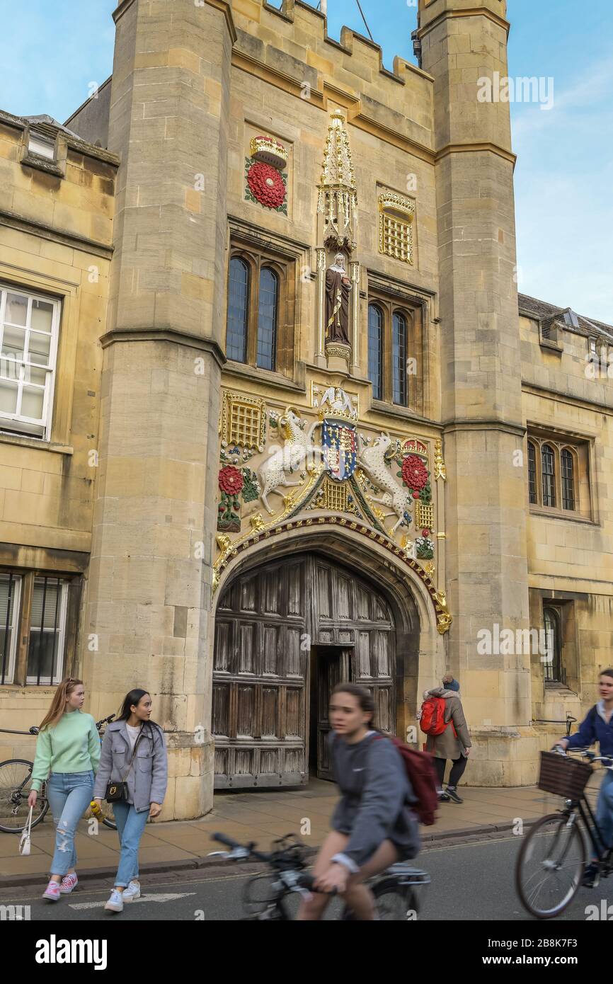 Ancient Door with Guilded Heraldry and Bike Riders at Christ College Stock Photo