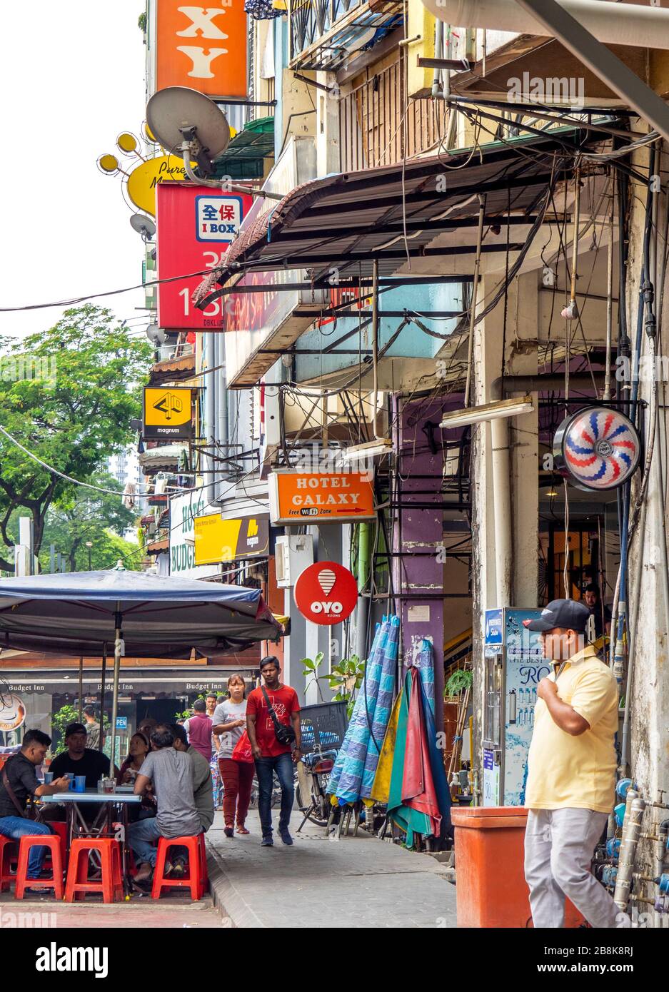 People eating al fresco style and tourists walking along Jalan Alor Street Bukit Bintang, Kuala Lumpur Malaysia. Stock Photo
