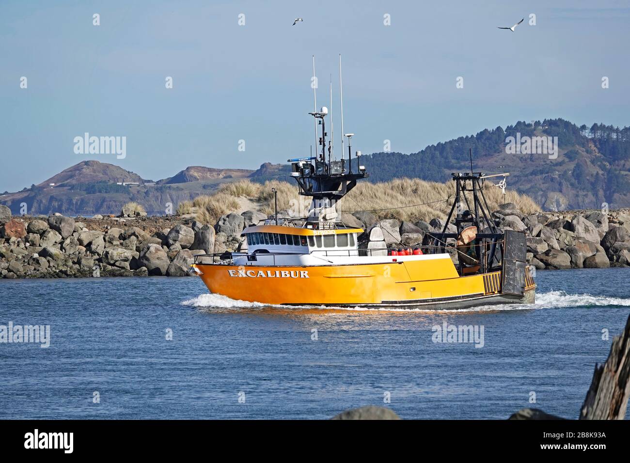 A large, brightly colored commercial fishing boat sails through the