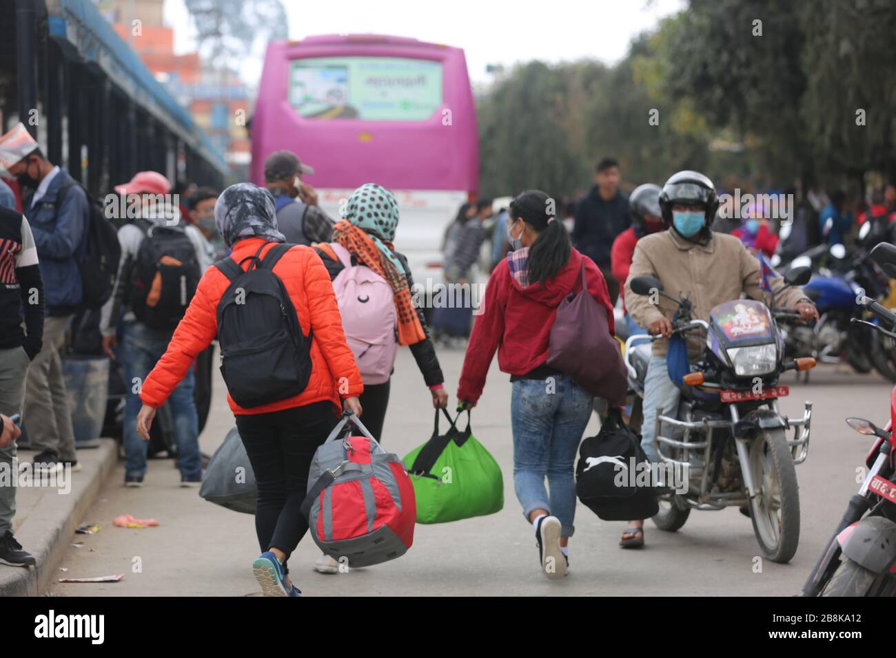 Kathmandu, Nepal. 22nd Mar, 2020. Passengers walk at a coach station in Kathmandu, Nepal, March 22, 2020. Nepali Prime Minister KP Sharma Oli on March 20 announced a number of prohibitive measures including suspension of long-distance transport operation amid COVID-19 outbreak. In an address to the nation on Friday evening, the prime minister announced that all the long-haul transportation services will be halted from March 23. Credit: Zhou Shengping/Xinhua/Alamy Live News Stock Photo
