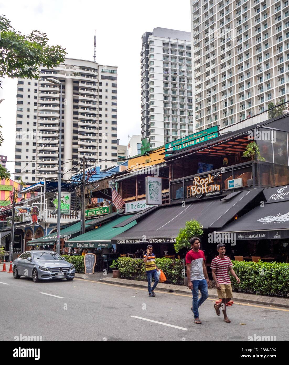 High rise residential towers behind row of bars and restaurants on Changkat Bukit Bintang street Kuala Lumpur Malaysia. Stock Photo