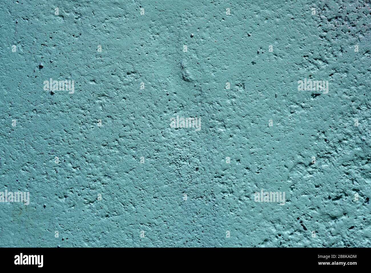 texture of a painted wall. cement plate light aquamarine color background. wall with bumps and small pits. Stock Photo