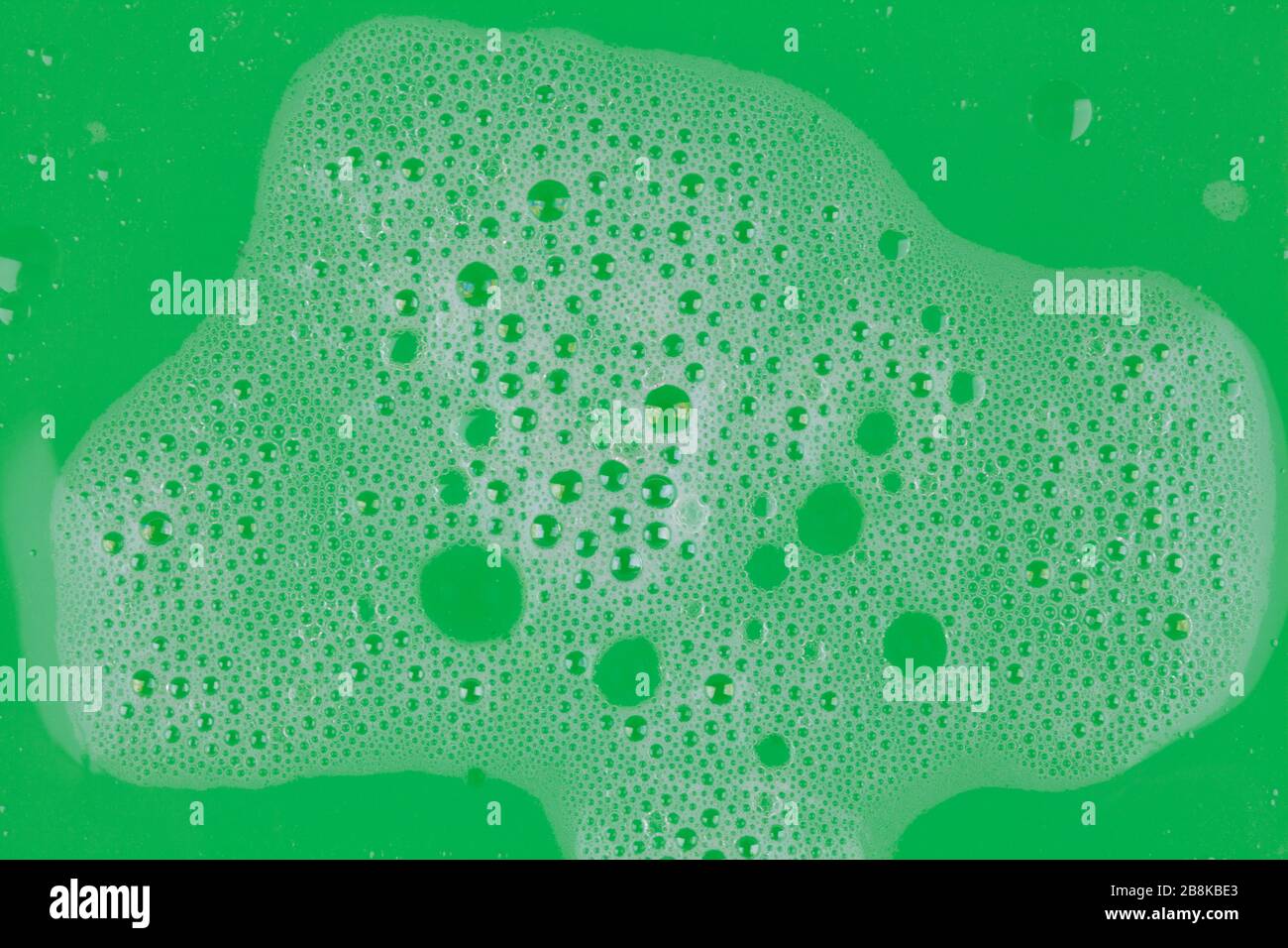 Abstract background white soapy foam texture on green background. Shampoo foam with bubbles Stock Photo