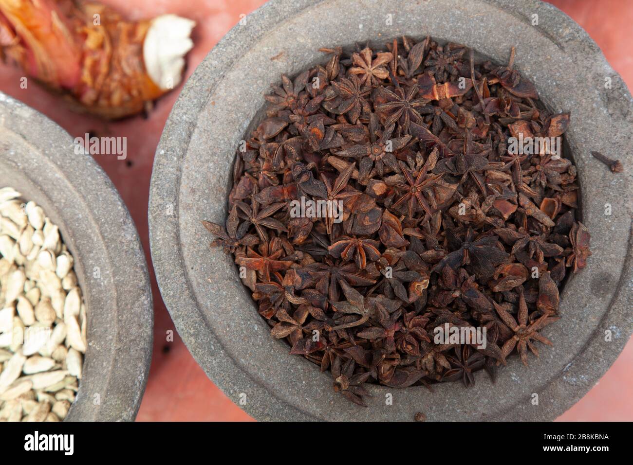 Display of dried star anise and ginger, in grey stone pot in Penang, Malaysia Stock Photo