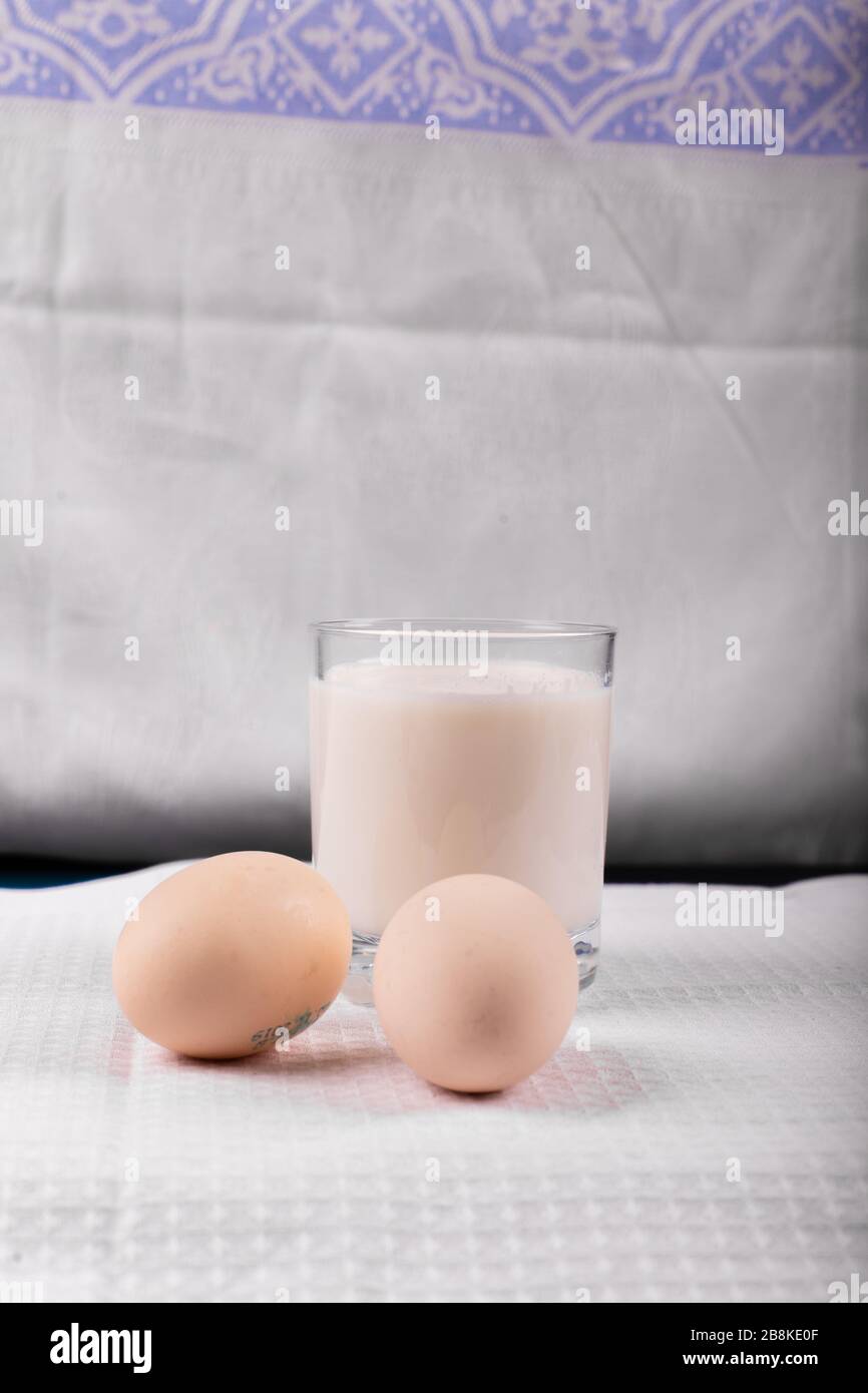 A glass of milk with raw eggs isolated on white background Stock Photo ...