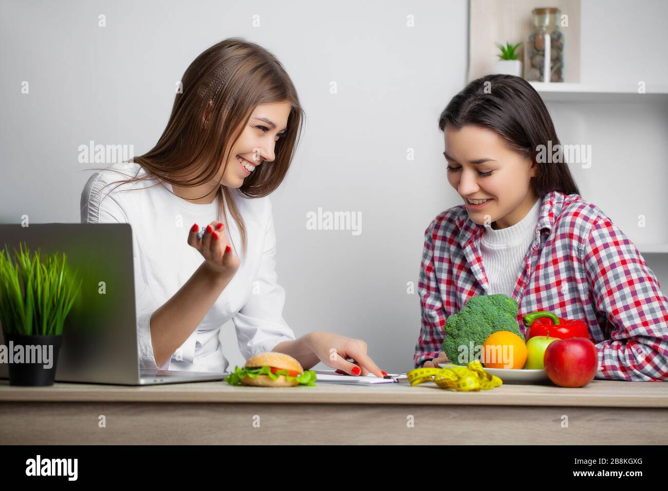 Woman in the white coat nutritionist writes a healthy diet program for ...