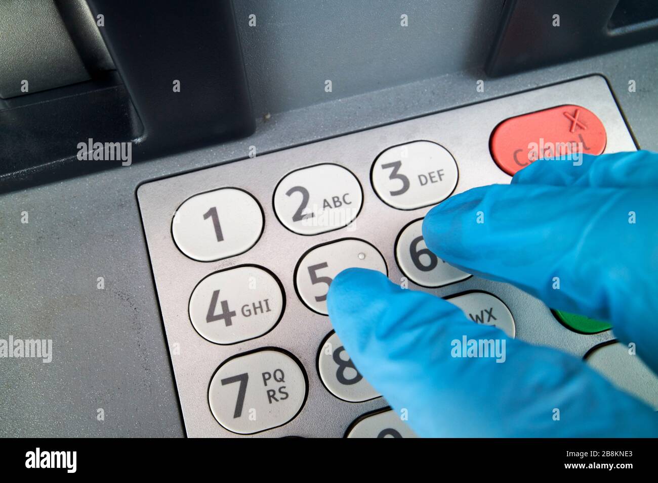 using gloved hand on dirty cash machine keypad due to covid19 precautions glengormley