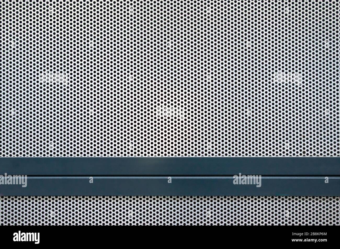 Section of a cover made of several plates of silver perforated plate, which are bordered with blue painted metal profiles Stock Photo