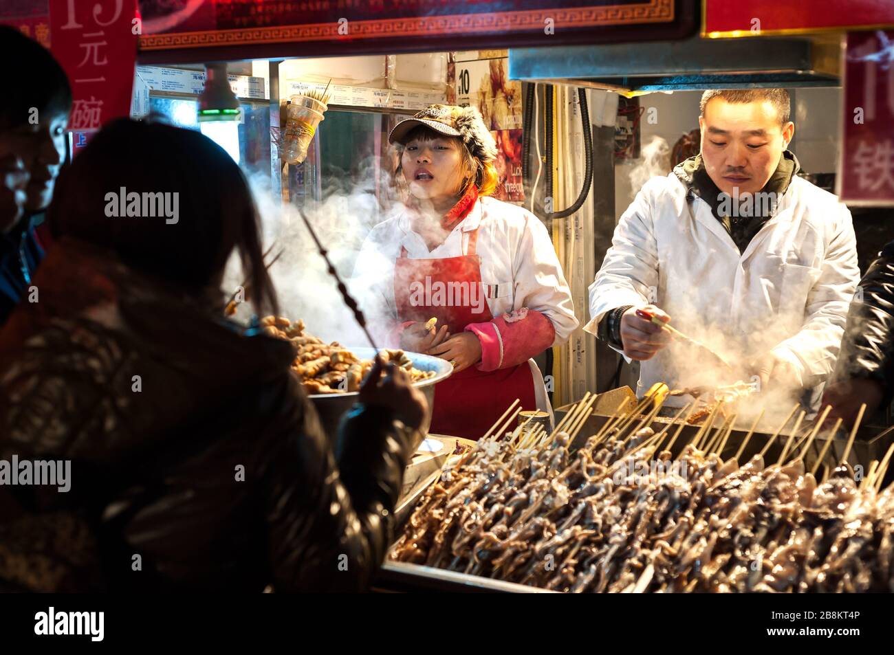 WANGFUJING NIGHT MARKET, BEIJING - DEC 25, 2013 - Snack vendors selling strange meat on sticks at Wangfujing snack street, Beijing Stock Photo
