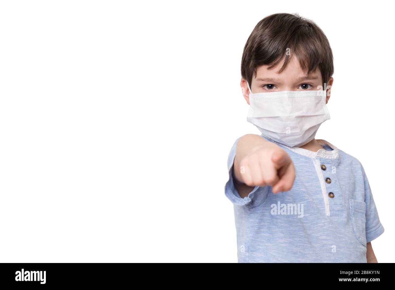 Little boy with face mask pointing finger towards viewer, isolated on