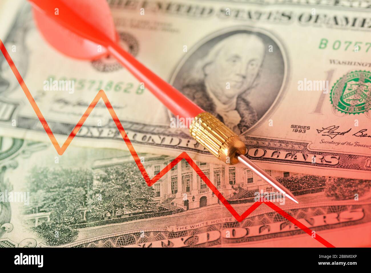 Red dart and graphic with descending line on dollar banknotes - Concept of lost money value Stock Photo