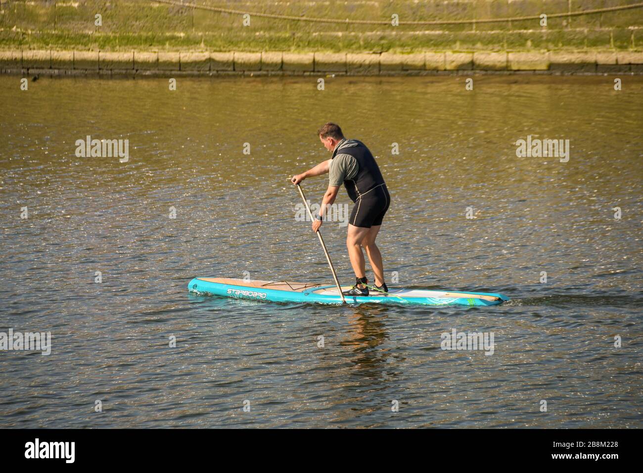 SWANSEA, WALES - JULY 2018: Person standing up on a paddle board on the River Tawe near Swansea marina Stock Photo