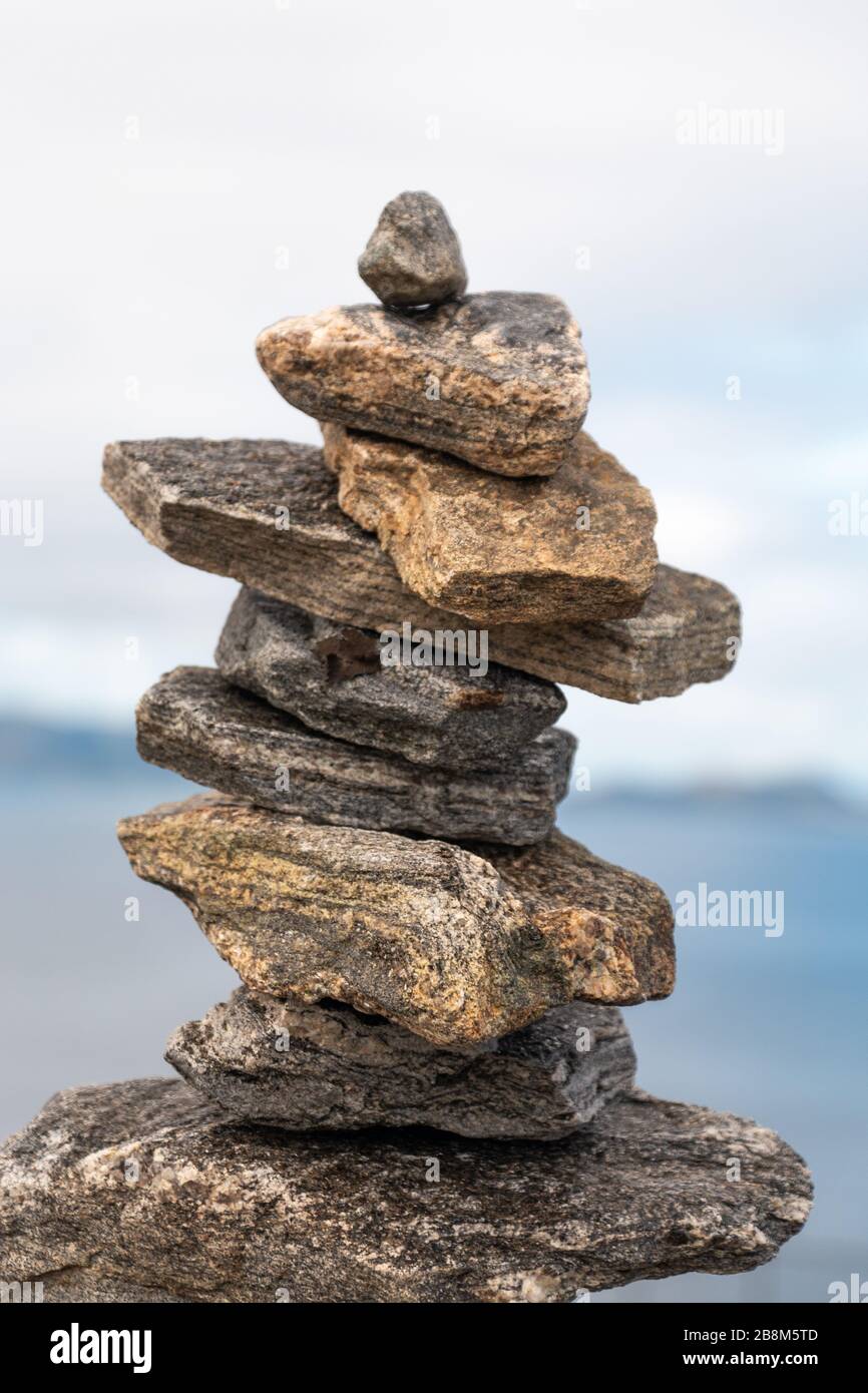 Stack of stones balanced on top of each other. clouds and ocean in background. Stock Photo