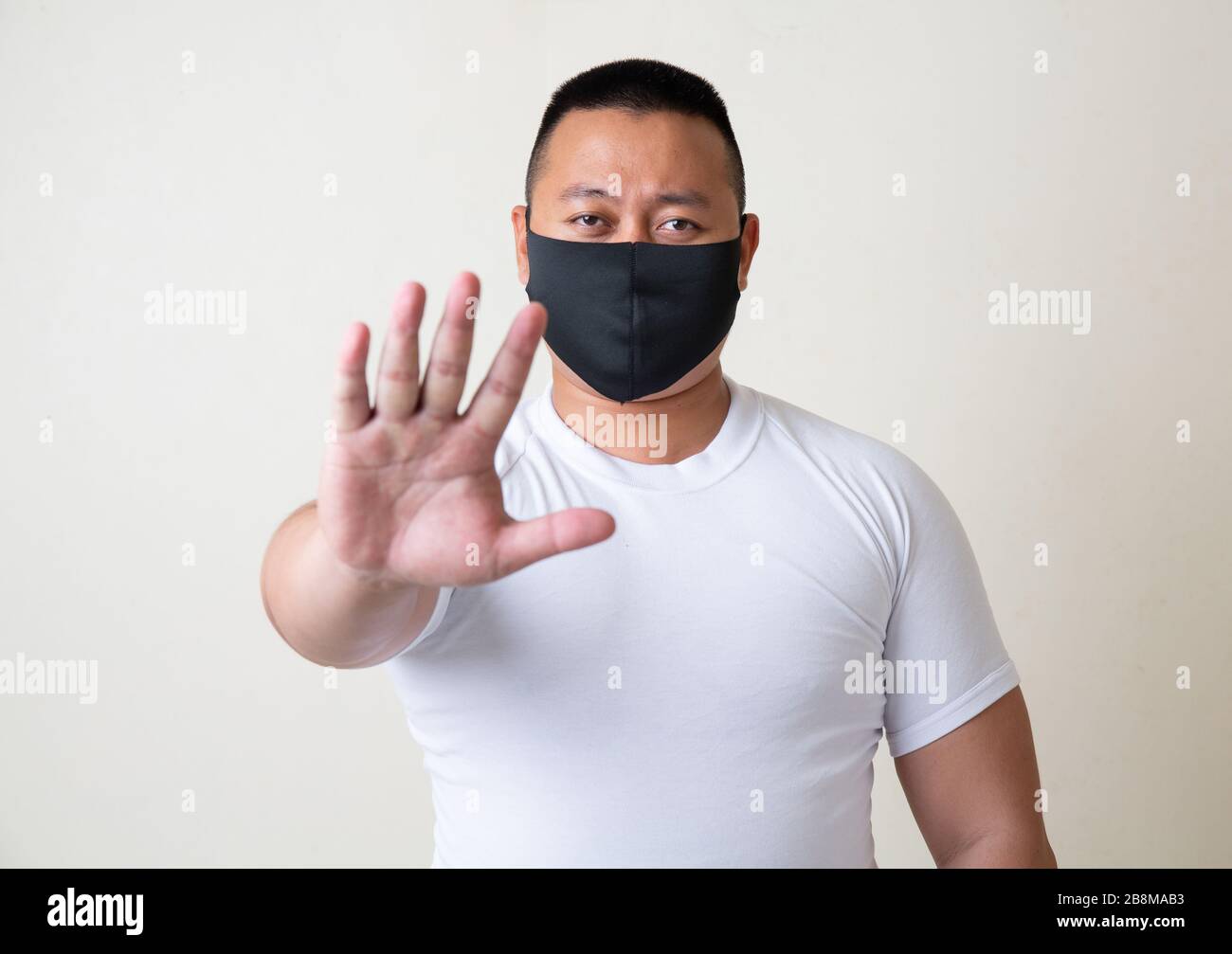 Asian Man in medical mask Coronavirus pandemic disease on grey background. COVID-19 virus from China epidemic outbreak to global recession concept for Stock Photo
