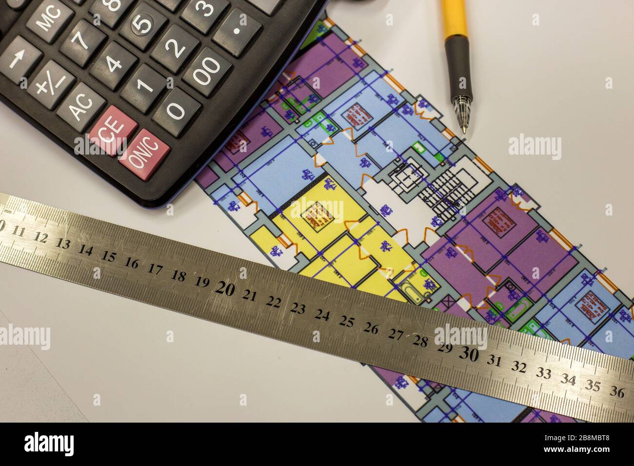Top view of calculator, pen and ruler on blueprint plan of architecture