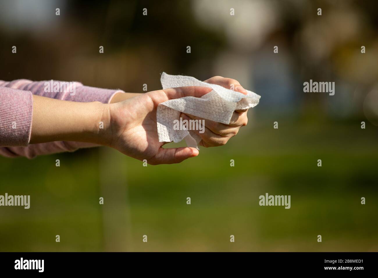 Cleaning hands with antibacterial wet wipes outdoor against disease
