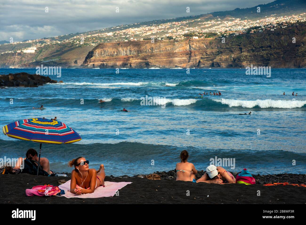 Tourists at los gigantes cliffs volcanic black sand beach in Puerto de la Cruz, Tenerife Island, Canary Islands, Spain Stock Photo