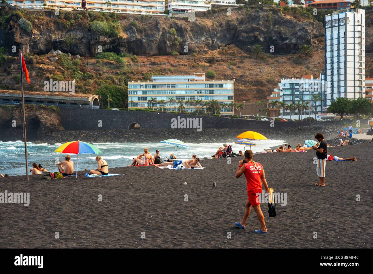 Tourists at los gigantes cliffs volcanic black sand beach in Puerto de la Cruz, Tenerife Island, Canary Islands, Spain Stock Photo