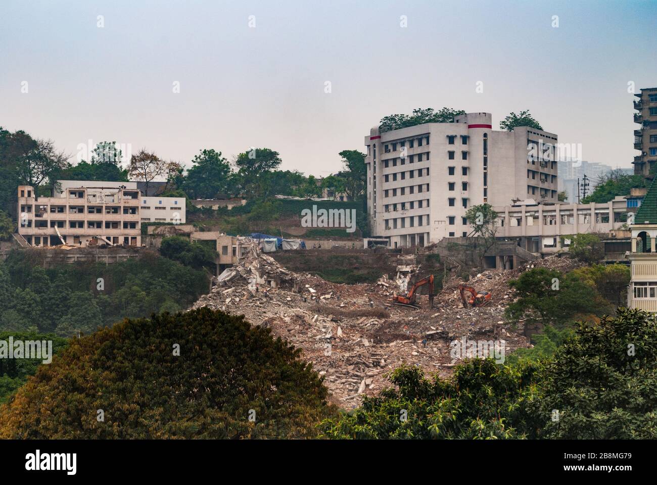 Chongqing, China - May 9, 2010: Downtown, off Peoples Square. Wide shot over huge demolition rubble site with old and newer buildings in back and some Stock Photo