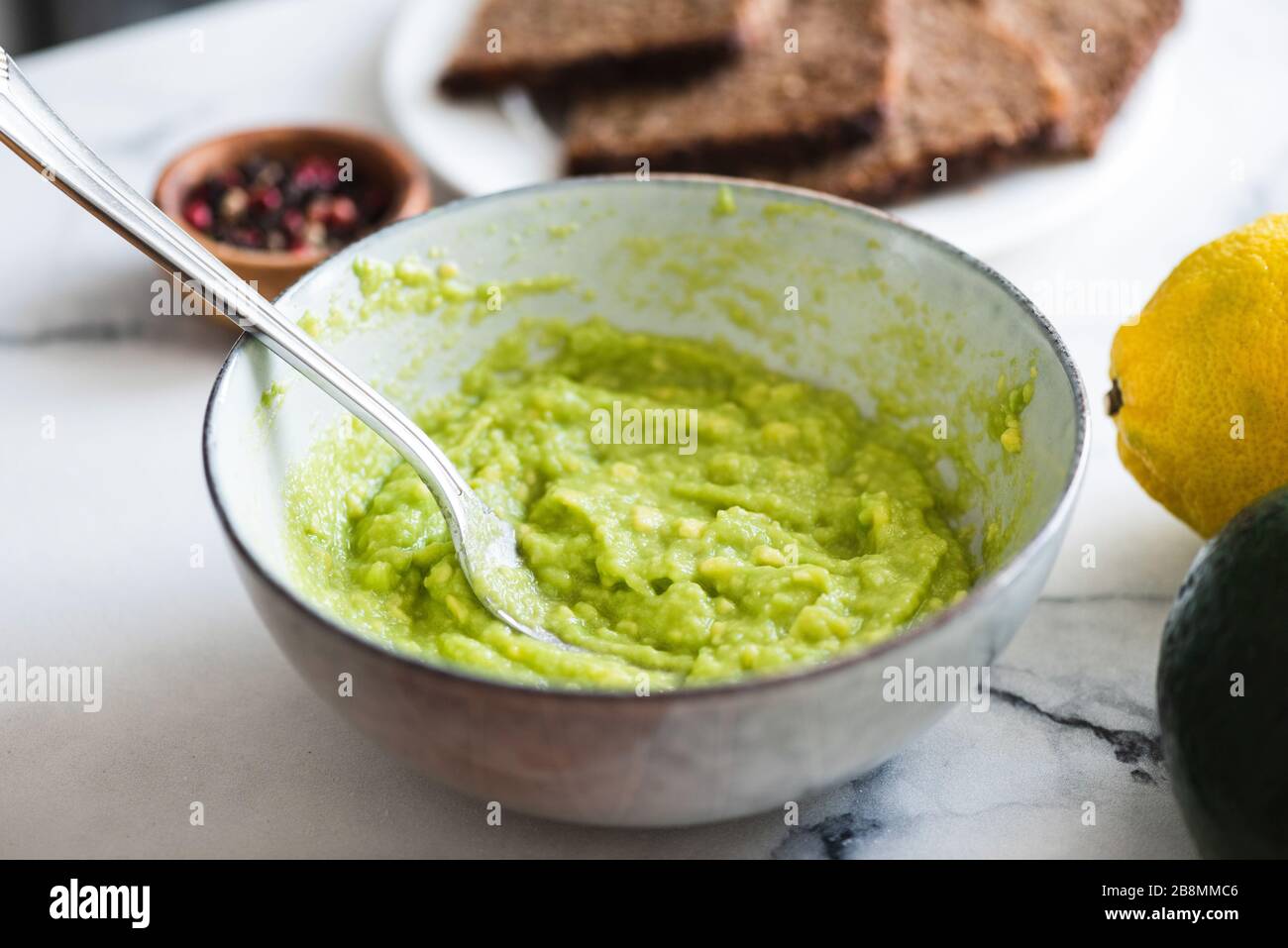 Mashed avocado sauce in bowl. Guacamole sauce, healthy vegan and vegetarian snack sauce Stock Photo